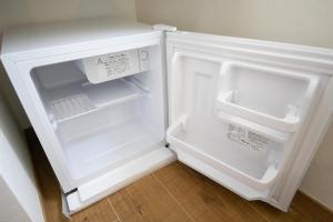 an empty refrigerator with its door open in a kitchen at Narita AIC Airport Hotel in Narita