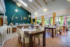 a dining room with tables and chairs in a restaurant at Ferien Hotel Spreewald in Kolkwitz