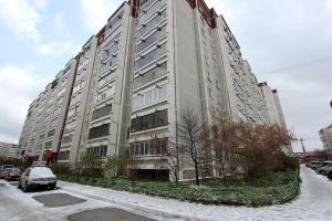 エカテリンブルクにあるАпартаменты на Родонитовой 3の車が目の前に停まった大きな建物