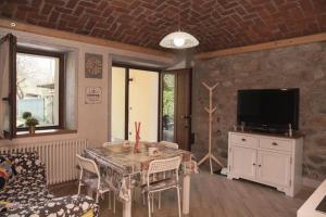 salon ze stołem i telewizorem w obiekcie casa margherita w mieście Borgo San Dalmazzo