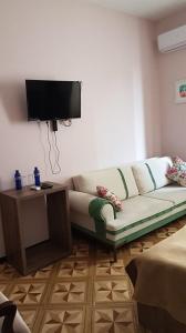 uma sala de estar com um sofá e uma televisão de ecrã plano em Hotel Classic em Tbilisi