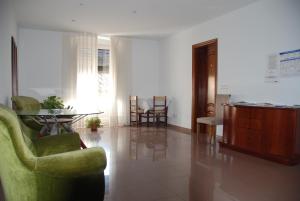 a living room with green chairs and a table at Pensió Viladomat in Girona