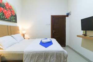 a bedroom with a bed with a blue towel on it at Labuana Homestay & Cafe Garden in Makassar +26 photos