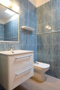 ein Badezimmer mit einem WC, einem Waschbecken und einem Spiegel in der Unterkunft Ca Sa Vilda in Es Pujols