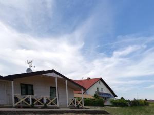 a white house with a red roof at Domek nad morzem in Będzino +2 photos