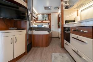a small kitchen with a bed in a trailer at Bergwelt-M - Scheunencamping in Schröcken