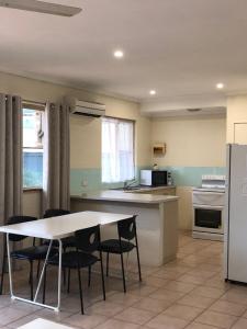 a kitchen with a table and chairs and a refrigerator at Pelican's Nest in Kalbarri