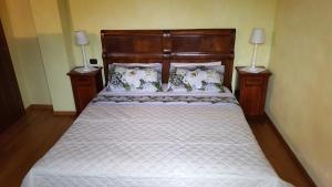 una camera da letto con un grande letto con due comodini di Corte La Guarnigione a Valeggio sul Mincio