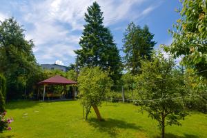 a garden with trees and a gazebo in the background at Pension Verona Centru in Cluj-Napoca