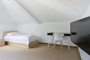 Dormitorio con cama, escritorio y TV en Pension Verona Centru, en Cluj-Napoca