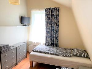 um pequeno quarto com uma cama e uma janela em Beltes Guest House em Jūrmala