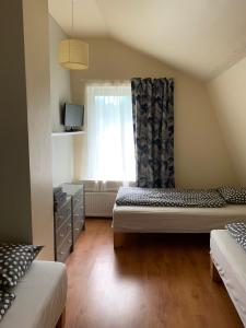 a small room with two beds and a window at Beltes Guest House in Jūrmala