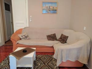 een woonkamer met een witte bank met kussens bij Apartman prvi red do mora in Crikvenica