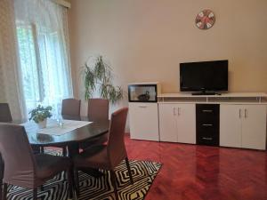 een woonkamer met een tafel en een televisie en een tafel en stoelen bij Apartman prvi red do mora in Crikvenica
