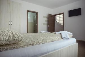 a bedroom with a large bed with a television on the wall at Casa Verona Centru in Cluj-Napoca