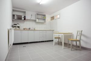 a kitchen with white cabinets and a table and a microwave at Casa Verona Centru in Cluj-Napoca