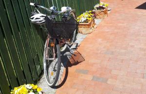 Una bicicleta con una cesta estacionada junto a una valla en Pension Marina, en Lauta Dorf
