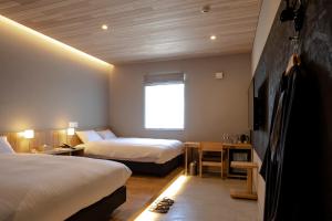 Rúm í herbergi á MASCOS HOTEL Masuda Onsen