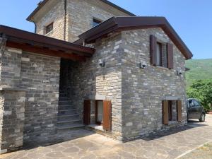 a brick building with a car parked in front of it at FuoriPorta Affitti Brevi - Borgo Scorza in Pietramogolana
