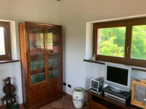 a living room with a tv and a cabinet and a televisionictericter at FuoriPorta Affitti Brevi - Borgo Scorza in Pietramogolana