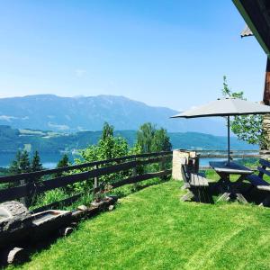 stół piknikowy i parasol na szczycie wzgórza w obiekcie Reinwalds Almhütte w mieście Millstatt am See