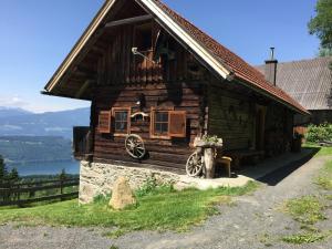 una cabaña de madera con una rueda delante de ella en Reinwalds Almhütte, en Millstatt