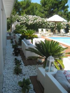 un patio con mobili bianchi e una piscina di Malia Village a Vieste