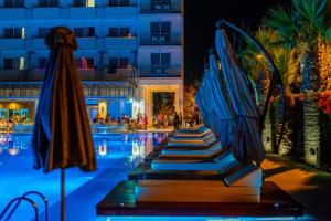 a swimming pool with umbrellas and a hotel at Nestor Hotel in Ayia Napa