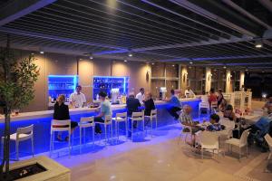 a group of people sitting at a bar in a building at Nestor Hotel in Ayia Napa