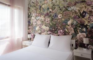 a bedroom with a floral wall mural and a bed at Rooms & Apartments Bruno in Split