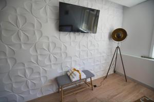 uma sala de estar com televisão numa parede branca em Camoes StudioGeral em Brangança