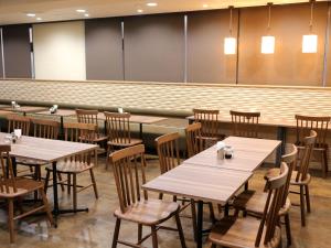 堺市的住宿－堺市太陽廣場酒店，用餐室配有木桌和椅子