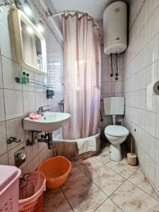 a bathroom with a sink and a toilet and a shower at Da Vinko Beach Apartments in Split