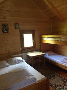 two beds in a wooden cabin with a window at Popas Turistic Padis in Padis