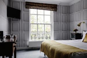 a bedroom with a bed and a large window at Pembroke Townhouse in Dublin