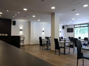 un restaurante con mesas y sillas y un bar en Hotel Castillo, en Villarrobledo