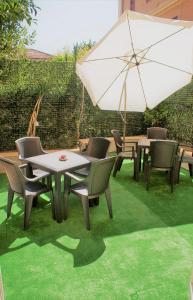 a patio with tables and chairs and an umbrella at B&B Metropolitan RC in Reggio di Calabria