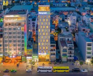 a city at night with a tall building at Merry Land Hotel Da Nang in Danang