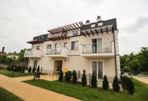 una gran casa blanca con árboles delante de ella en Apartament Lublin Stare Miasto "Wild Cat" en Lublin