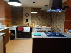 a kitchen with a stove and a counter top at A Casa do Ferrador in Vilar