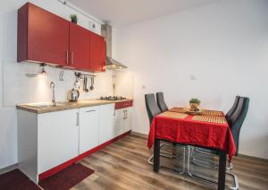 kuchnia ze stołem z czerwoną tkaniną w obiekcie Apartament Lublin Stare Miasto "Wild Cat" w mieście Lublin