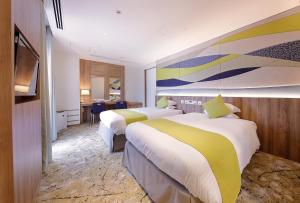 a hotel room with two beds and a television at Hotel Granvia Okayama in Okayama +43 photos