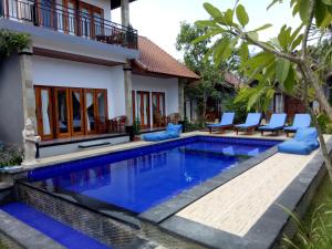 a villa with a swimming pool in front of a house at Radya Homestay in Nusa Lembongan