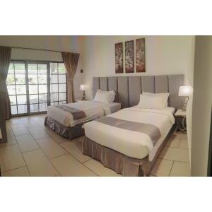 ein Hotelzimmer mit 2 Betten und einem Fenster in der Unterkunft Marina Point Bay Resort in Panglao