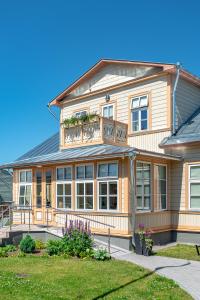 a large wooden house with a balcony on it at Villa Frieda in Haapsalu