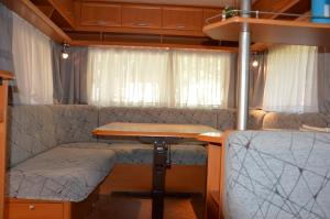 a dining table and a desk in an rv at Camping Du Parc in Pré-Saint-Didier