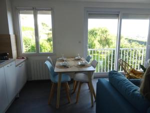 a table and chairs in a living room with a balcony at Côte et Mer in Le Portel