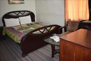 a bedroom with a bed and a table and a desk at Tulip guesthouse in Islamabad