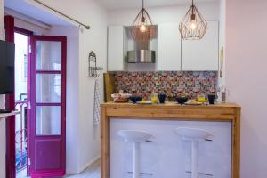 una cocina con encimera con taburetes. en Casa com Graça - Fully equiped Studio in the Historical Center, en Lisboa