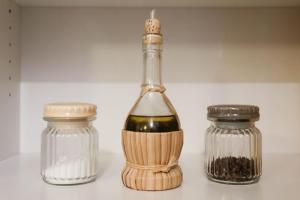 a bottle of wine with a whisk next to two glass jars at Domus Titiana Amazing Apartment in Trastevere in Rome +16 photos